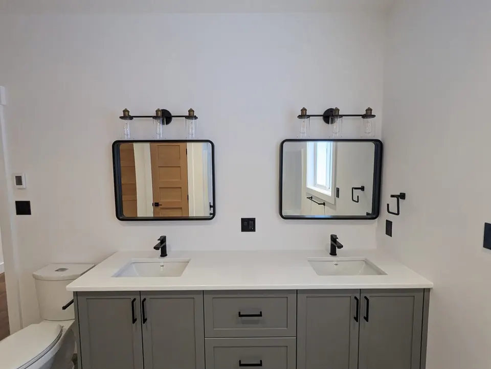 Bathroom with white walls and grey vanity cabinets