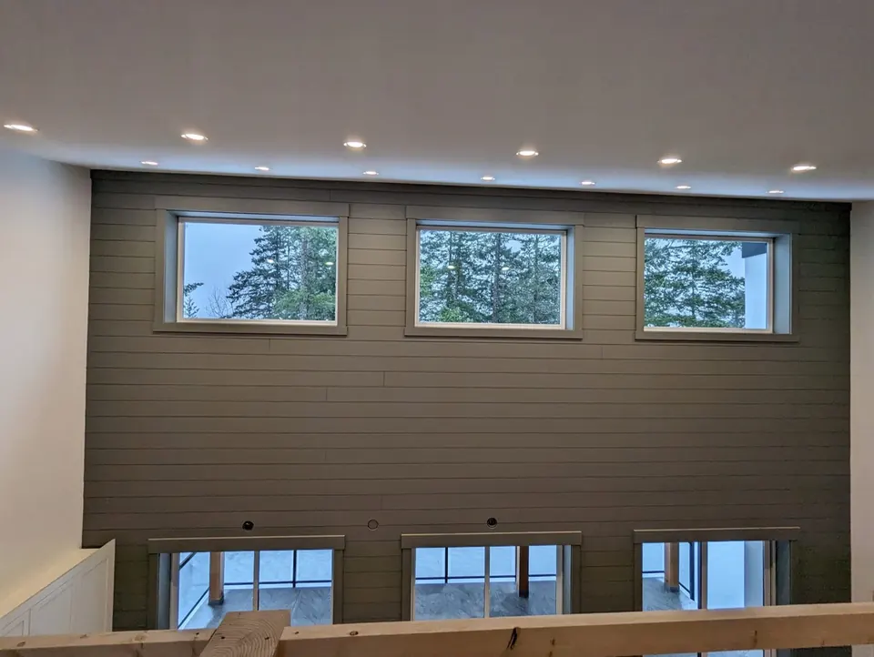 Dark grey shiplap wall with white window trim