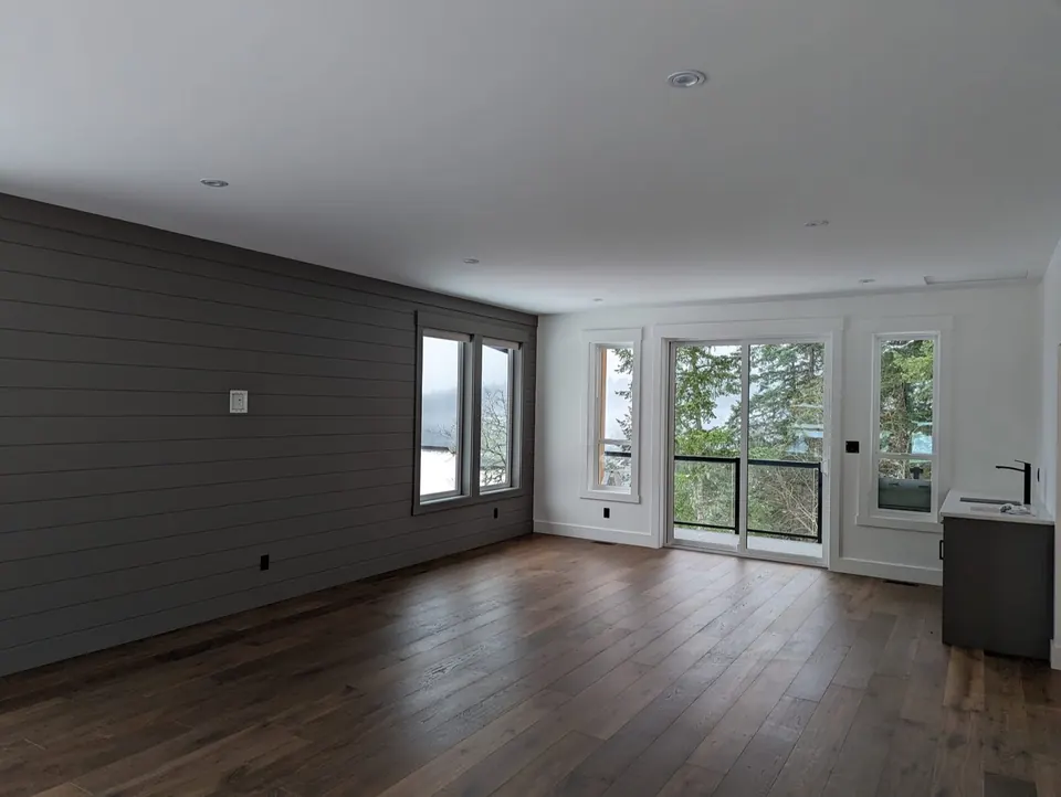 Condo living room with a dark shiplap feature wall and white walls, interior painting in the Comox Valley
