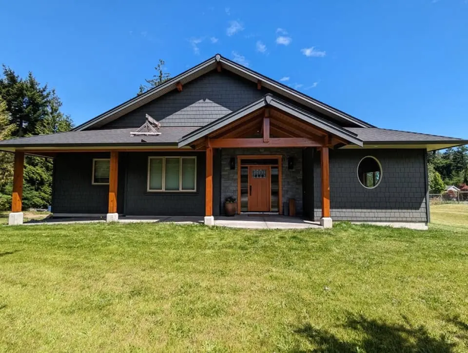 Finished timber-frame home with dark siding and stained timbers