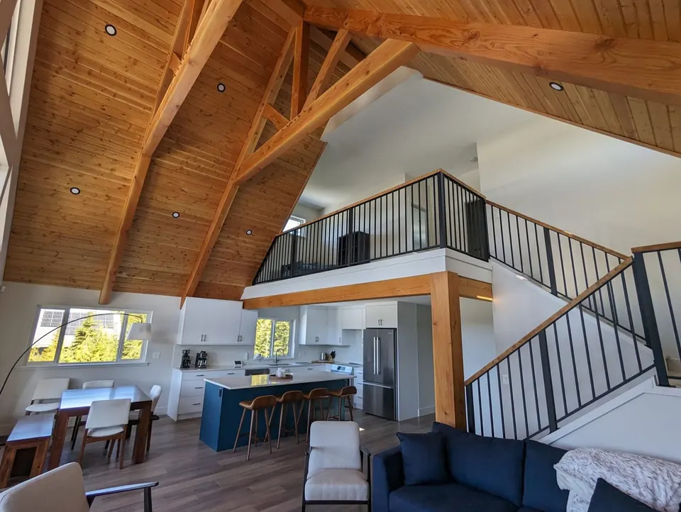 Timber-frame great room with white walls and stained trusses, new construction painting