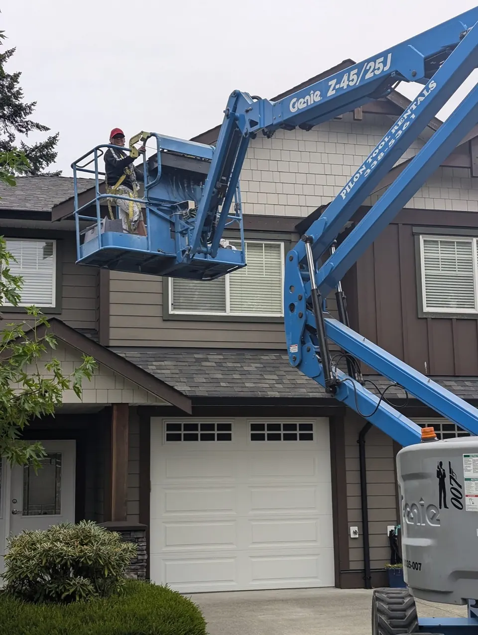 Painter on a boom lift at a townhouse gable